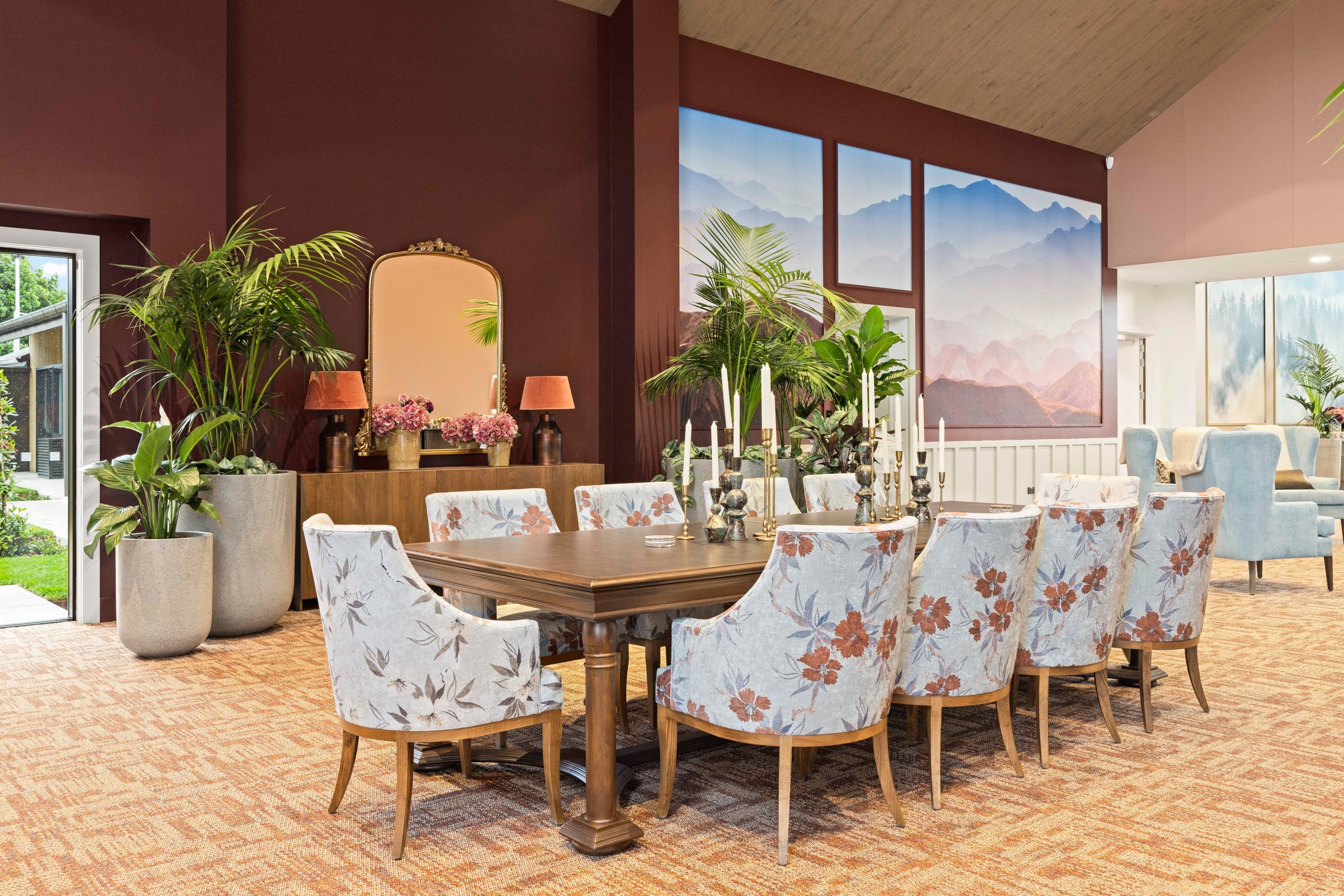 Formal dining table with floral upholstered chairs and mountain artwork at Tamahere Country Club, photographed for Acorn Furniture