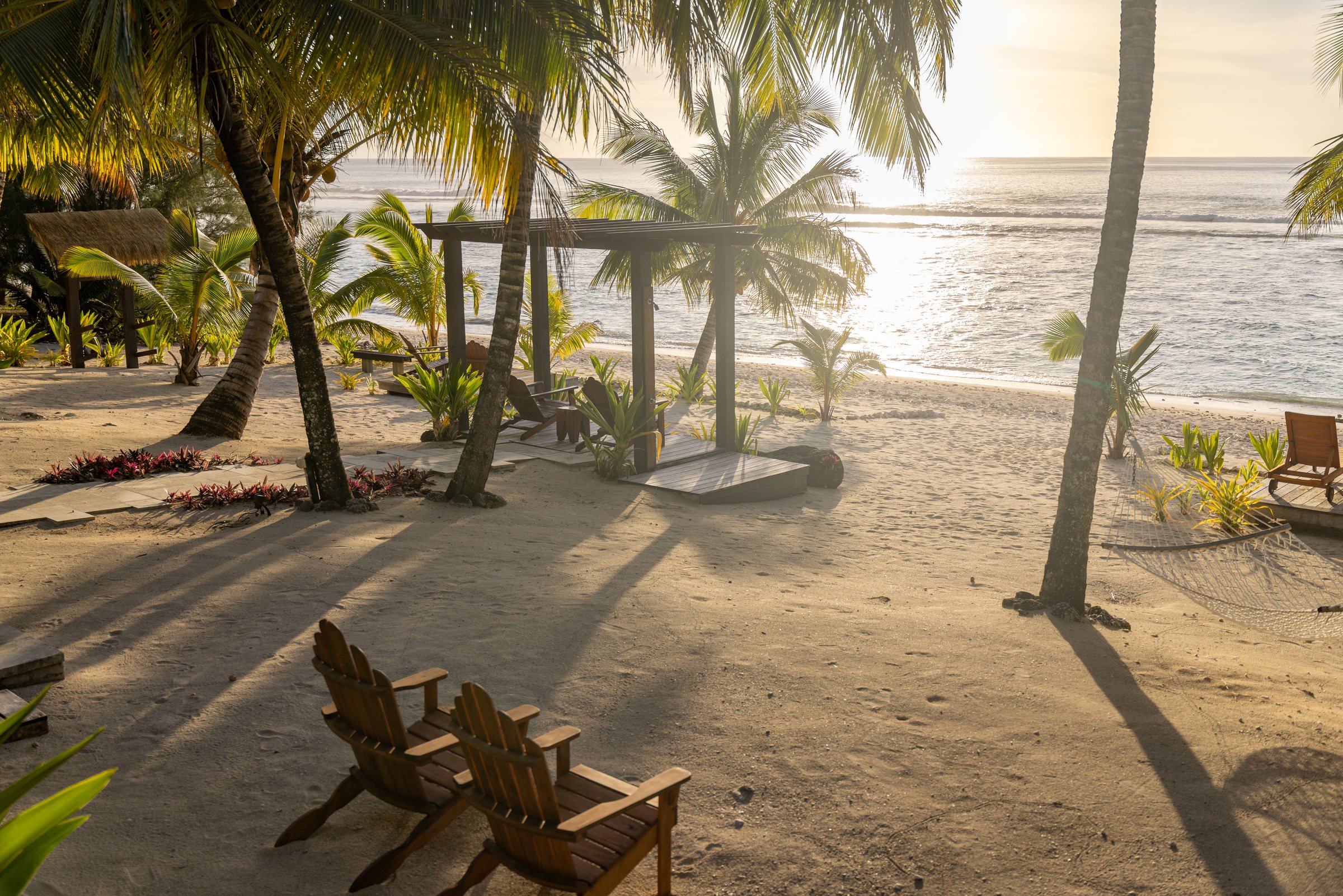 Poolside loungers beneath a thatched cabana at Serenity Villas