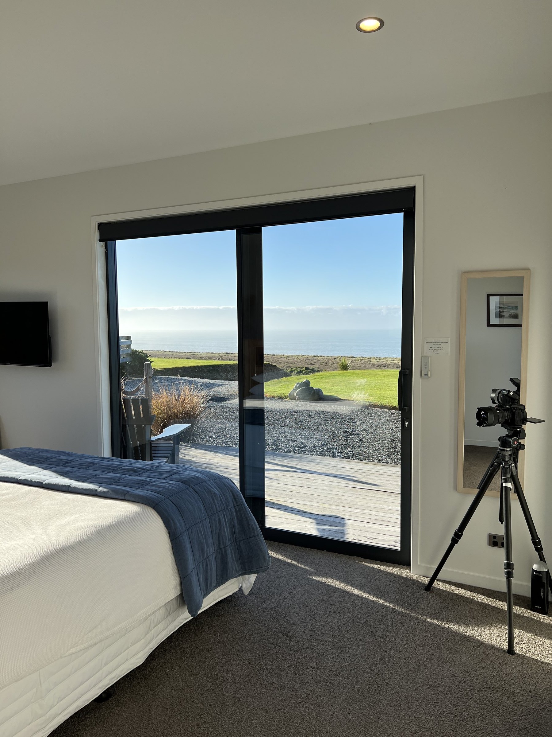 Camera set up on a tripod in a coastal accommodation suite during a property shoot