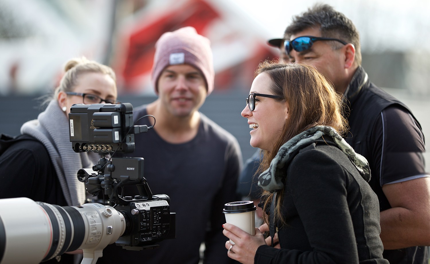 The crew reviewing a shot together around a cinema camera on location