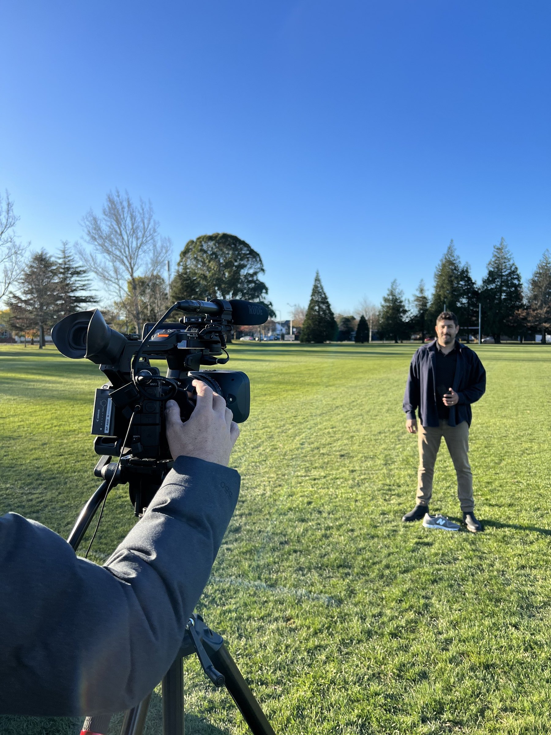 Filming a piece to camera with a presenter on a Christchurch sports field