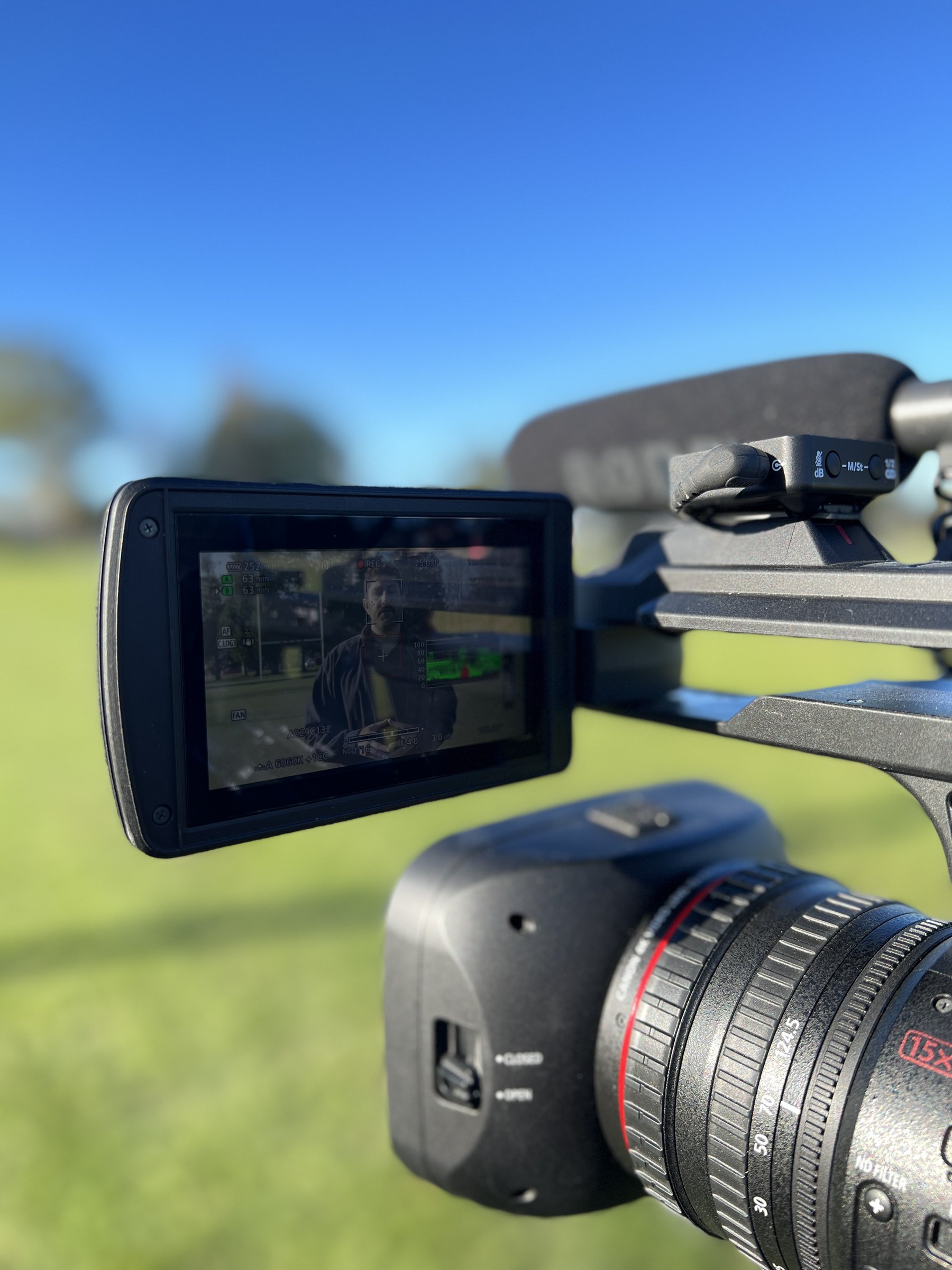 Close-up of a camera monitor while filming a presenter on a sports field