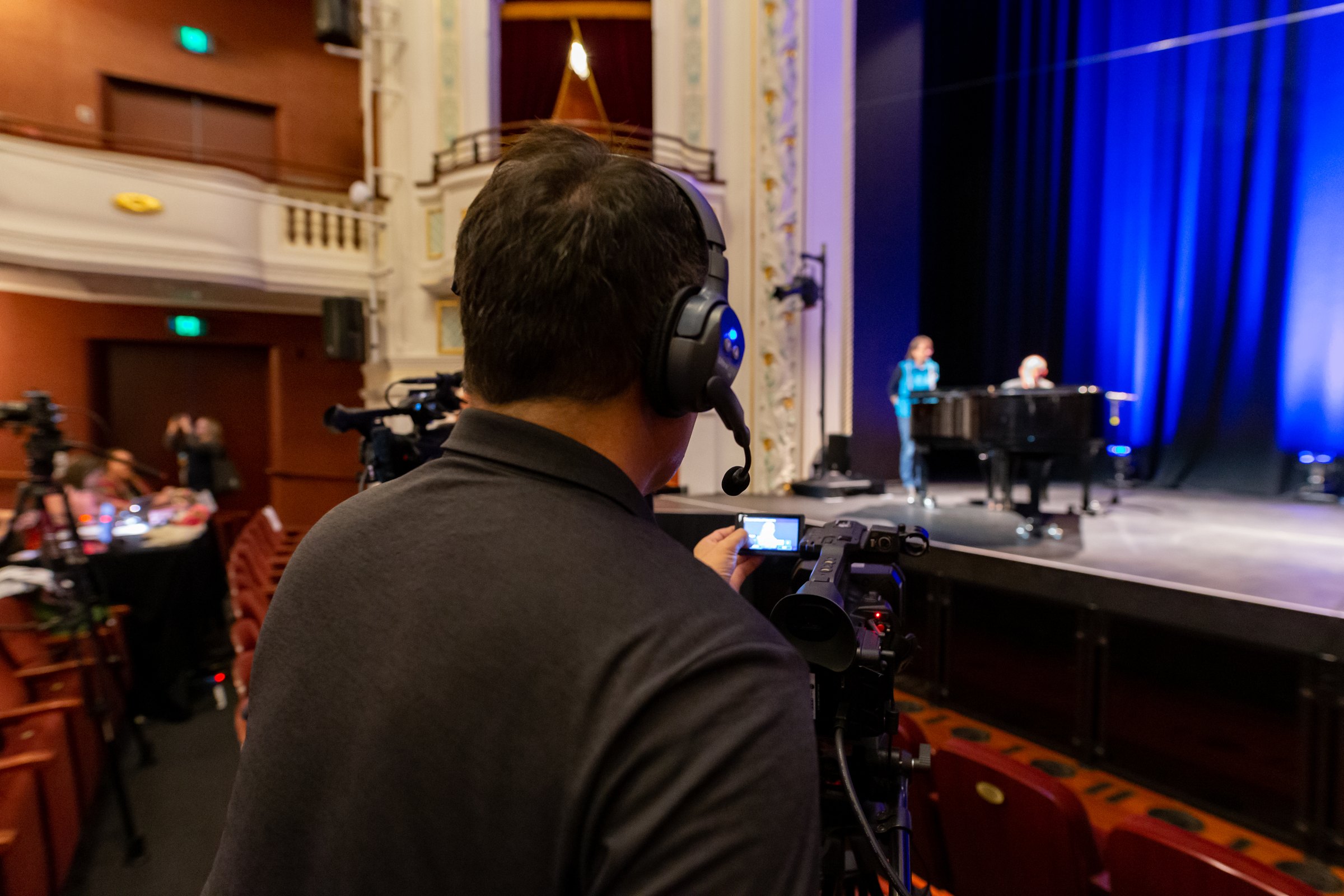 Parallax Films camera operator filming a live event in an ornate heritage theatre