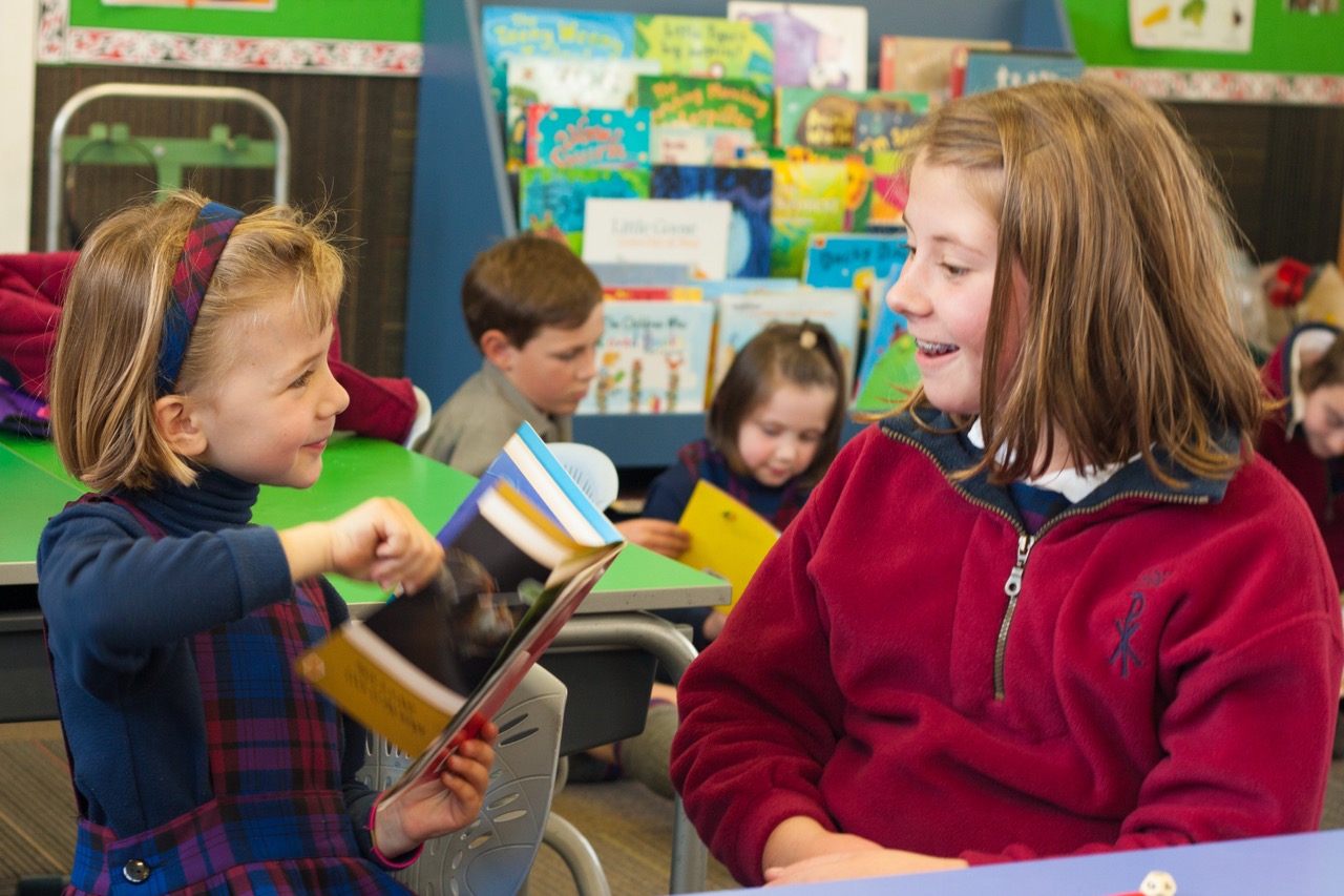 Christ the King School students sharing books in the classroom