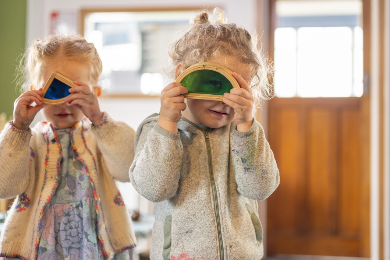 Two Waka Huia Childcare children looking at the rabbit hutch