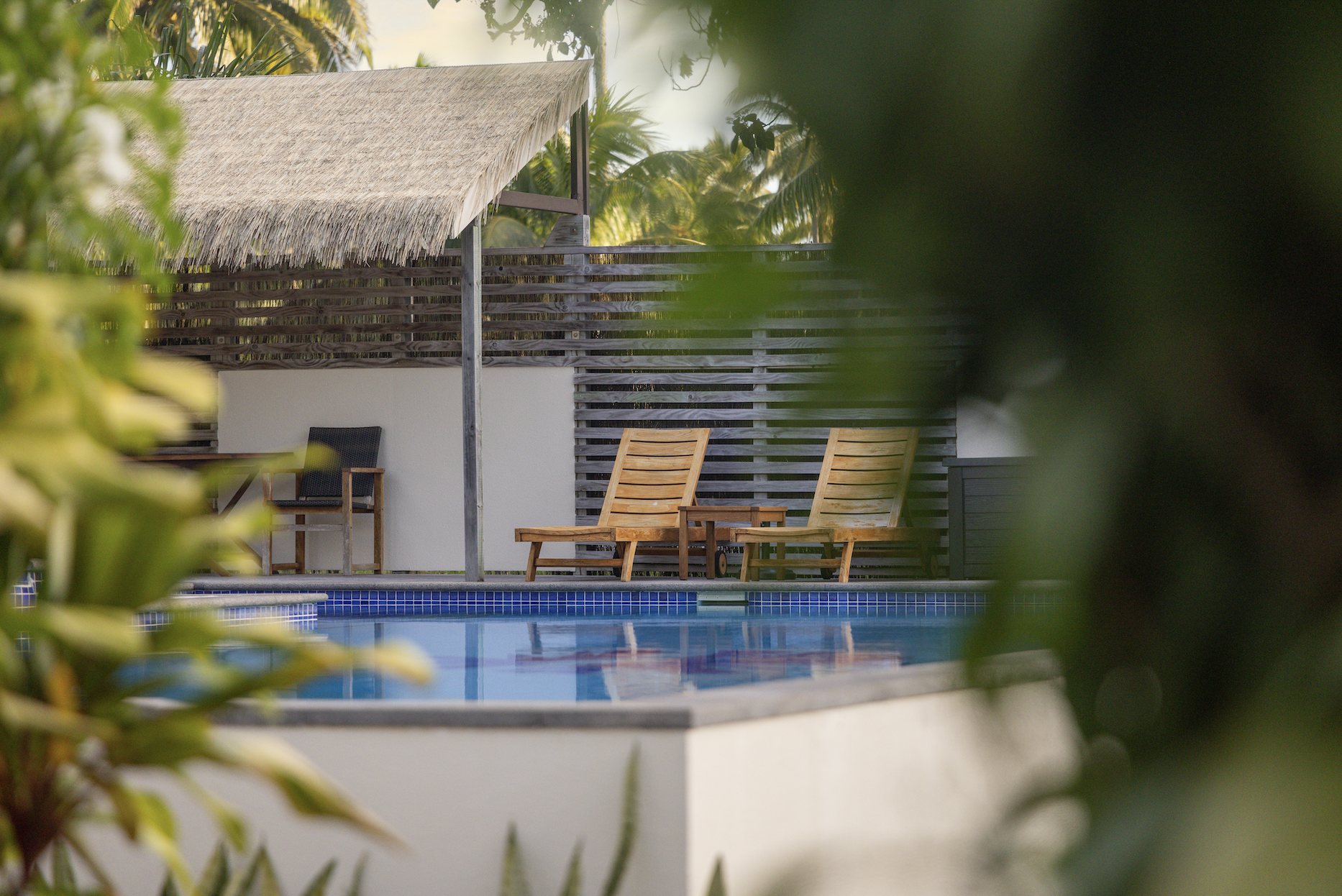 The pool at Serenity Villas glimpsed through tropical foliage